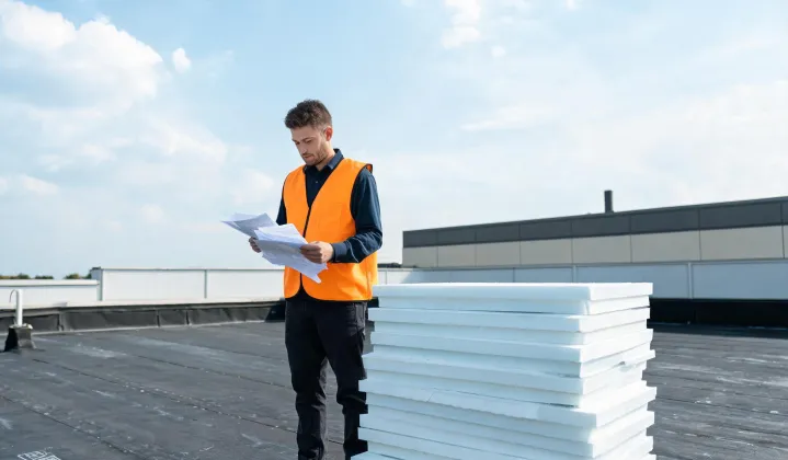 Engineer reviewing insulation TDS on a commercial roof deck